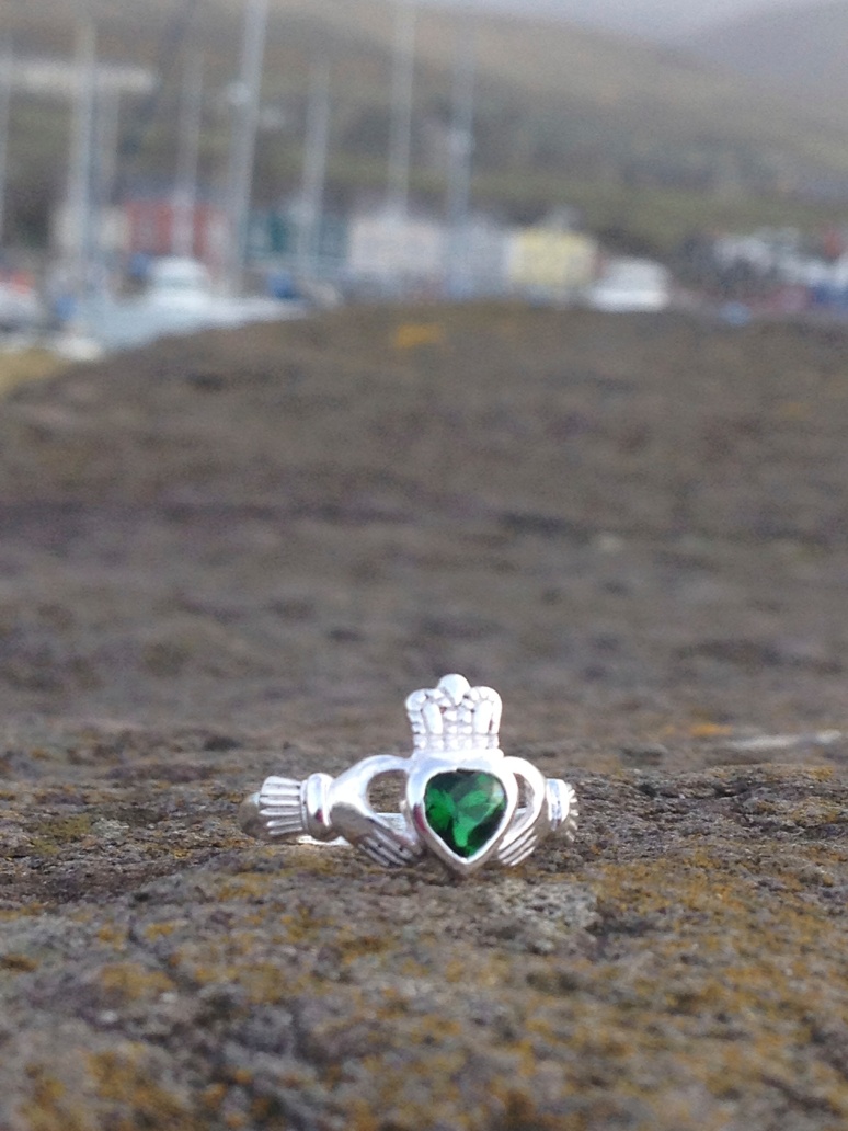 This is a Claddagh ring, a traditional Irish wedding band.  The hands stand for loyalty, the crown stands for friendship and the heart stands for love. 